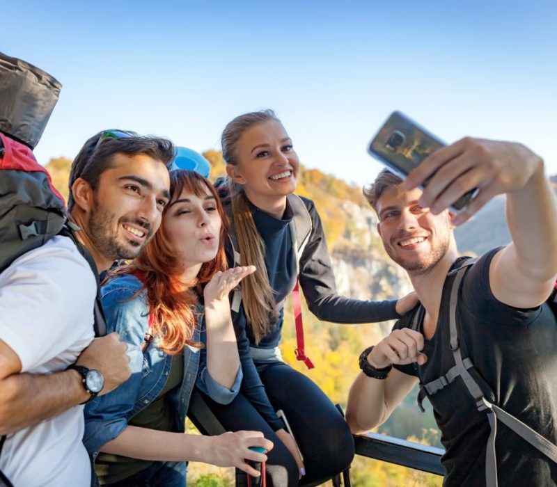 friends-with-backpacks-making-selfie-photo-together-at-the-peak-of-mount-travel-and-tourism-concept.jpg